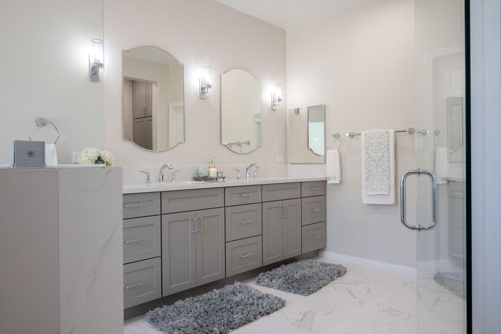 A Poway primary bath with a curbless shower, a freestanding tub and arched mirrors