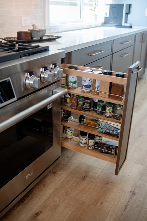 Four-tier pull-out spice rack in the cabinet beside the range