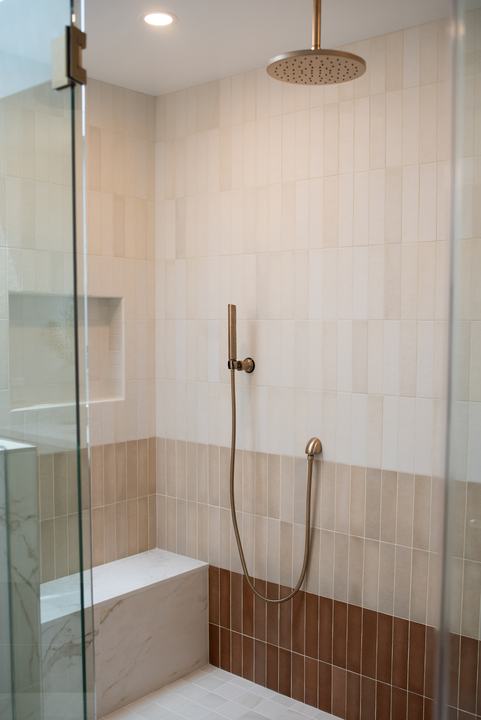 Ombre shower wall shading from white through beige to terracotta, with a marble-look bench