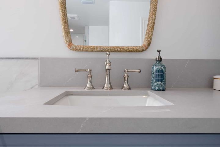 Undermount sink with chrome widespread faucet and quartz countertop detail