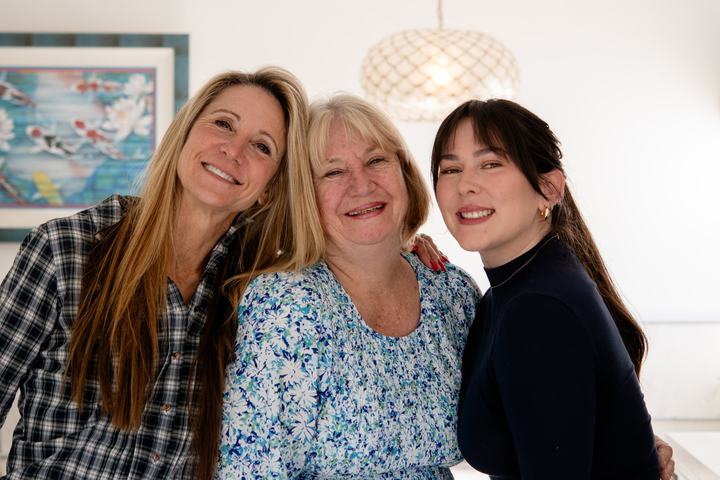 Design team and homeowner smiling in the completed primary bathroom remodel