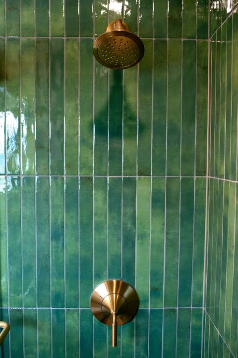 Master bathroom shower head and valve on green tile