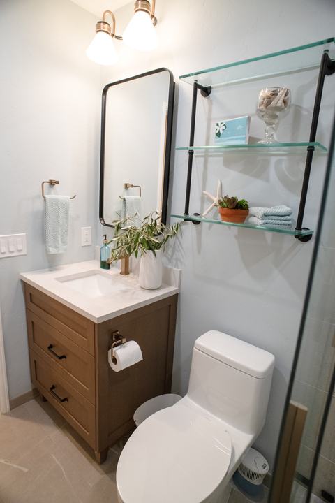 Teodor Bridgeport vanity with black pulls, a black-framed mirror, and glass shelves over the toilet