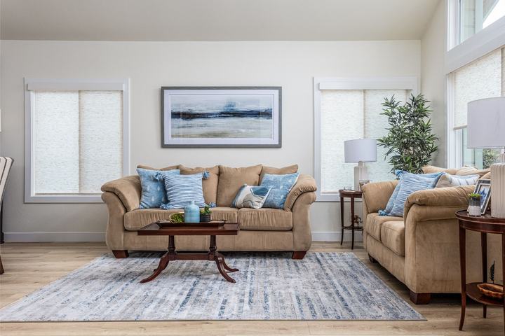 Bright living room with tan sofas, blue pillows