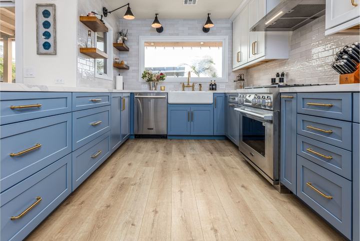 Blue cabinets and farmhouse sink with brass faucet