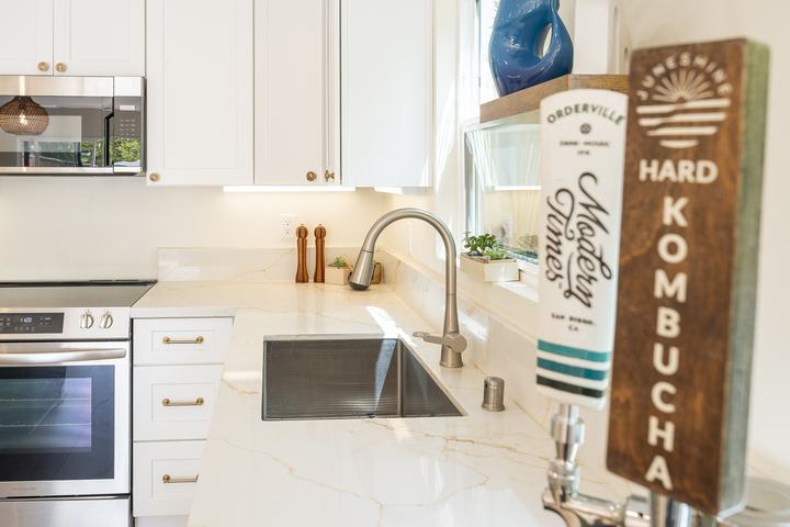 Sink wall with panel-ready Frigidaire dishwasher and quartz return