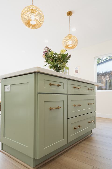 Island drawer stack with brass pulls and integrated outlet