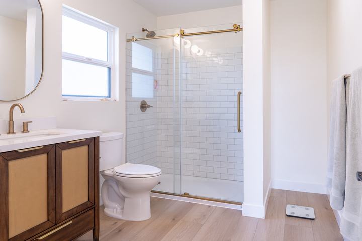 Primary bath double vanity with arched mirrors and brass faucets