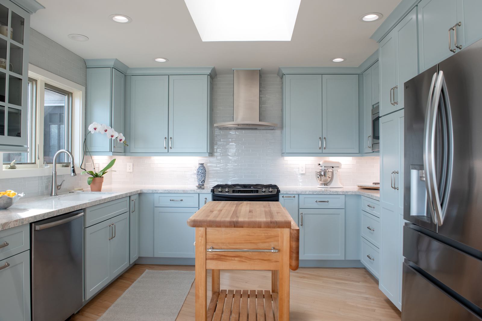 Wide view of Point Loma kitchen remodel with custom blue cabinetry, quartz counters, and stainless appliances