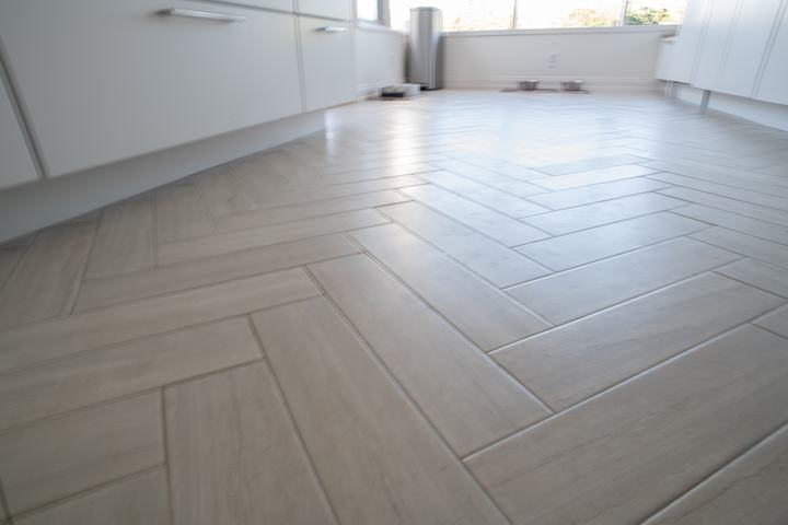 Limestone-look porcelain floor tile laid in a herringbone pattern