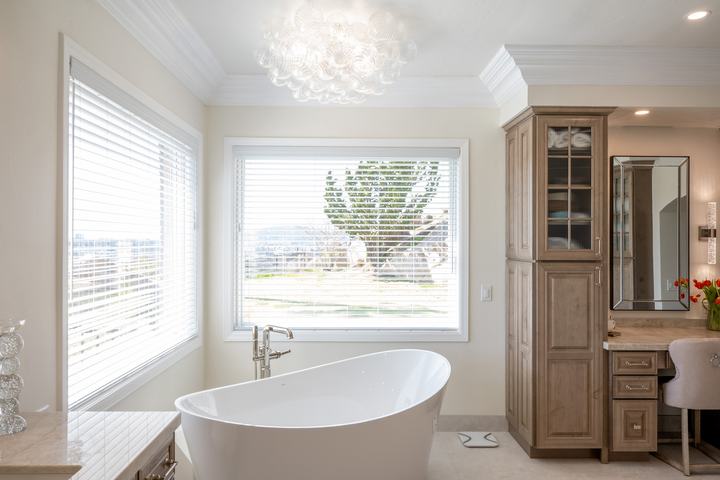Freestanding tub beneath bubble chandelier with panoramic Poway view through large window