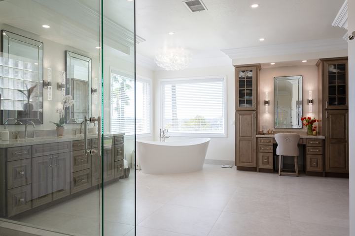 Wide shot of tub, vanity and slab-wall shower reflected in frameless glass enclosure