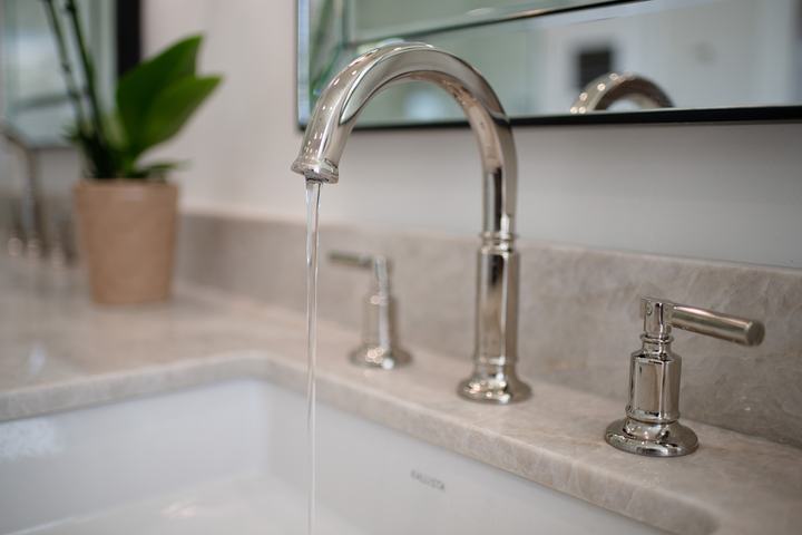 Brizo Invari widespread faucet running over Perla Venata quartzite counter and under-mount sink