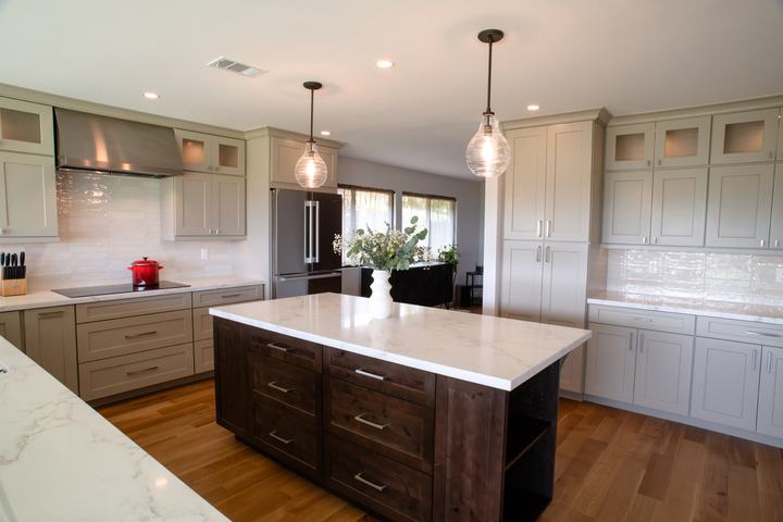 Knotty alder kitchen island with oatmeal perimeter cabinets and white backsplash