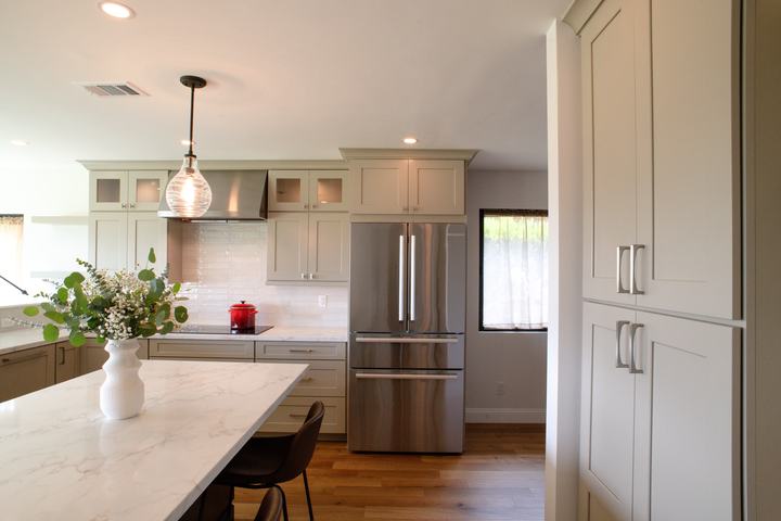 Remodeled kitchen with large island, induction cooktop, and tall pantry cabinets