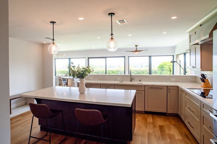 Large kitchen island with pendant lighting and wide window views