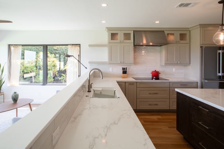 Kitchen sink and induction cooktop with glossy porcelain backsplash