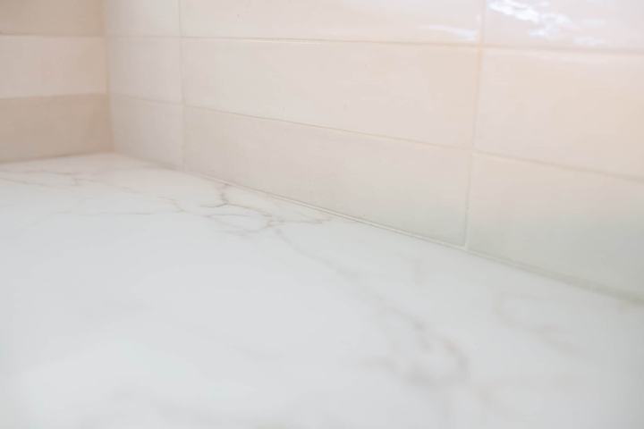Calacatta-style countertop and glossy porcelain backsplash detail