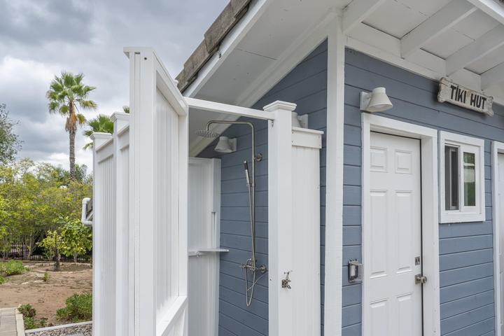 White outdoor shower enclosure with rain head