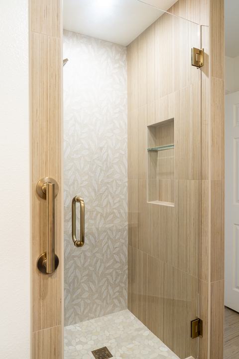 Shower entry showing Shibusa side walls and a recessed niche with glass shelf