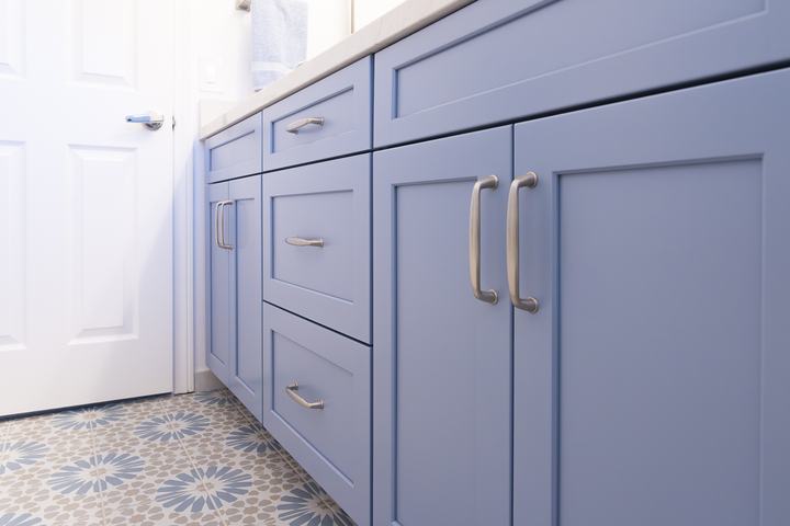 Low angle of blue vanity with Amerock Kane pulls over Ethnic patterned floor tile