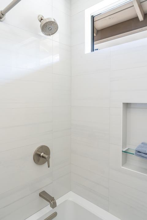 Kohler shower trim and tub spout over the Archer tub with large white wall tile