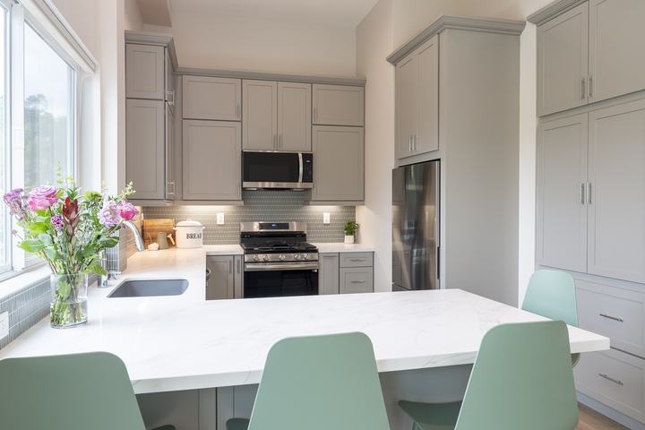 Quartz peninsula with flowers and soft-gray cabinetry