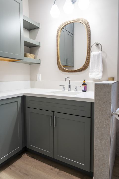 ADU bath with sage vanity, quartz top, brass mirror