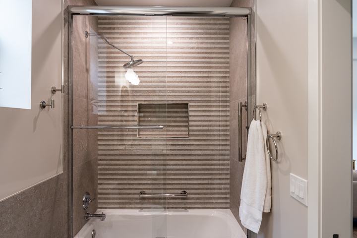 Striped Porcelanosa wall tile in tub-shower with niche