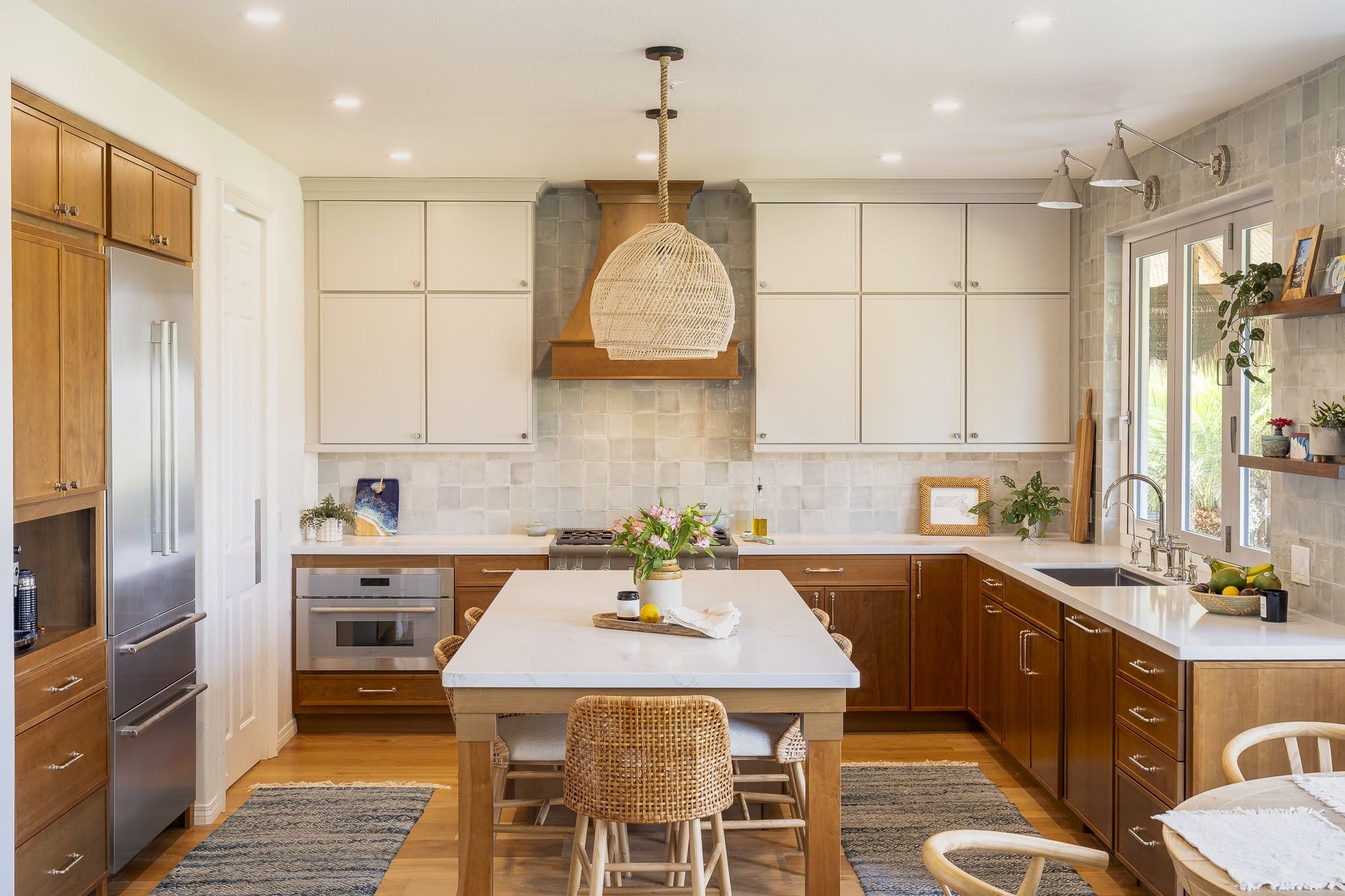 Encinitas kitchen remodel with two-tone cabinetry, a quartz island with seating and a custom wood hood
