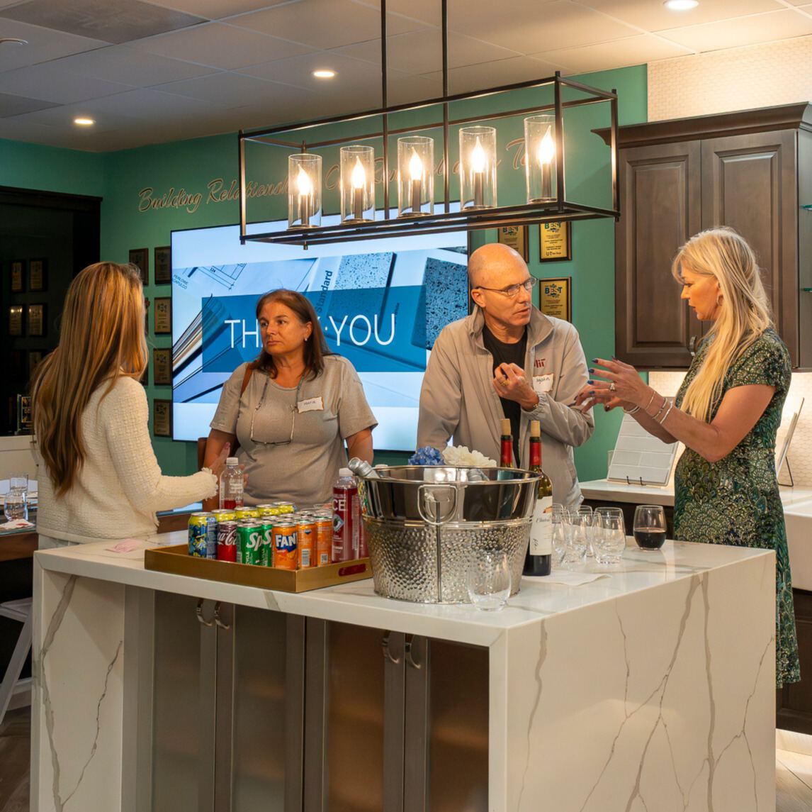 A free Kaminskiy design and remodeling seminar: homeowners around the showroom island with the design-build team