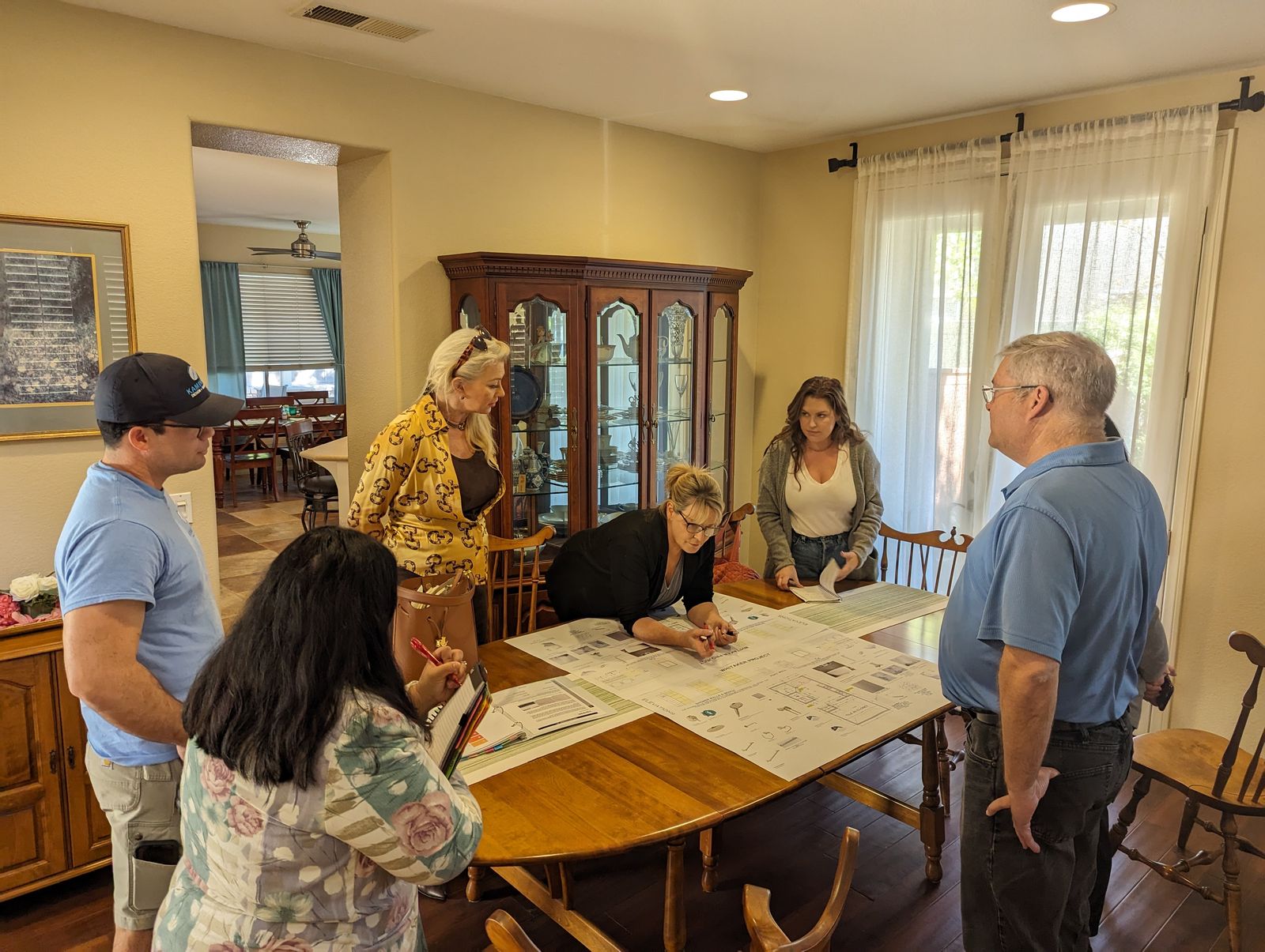 Kaminskiy designers reviewing plans with homeowners at their dining table