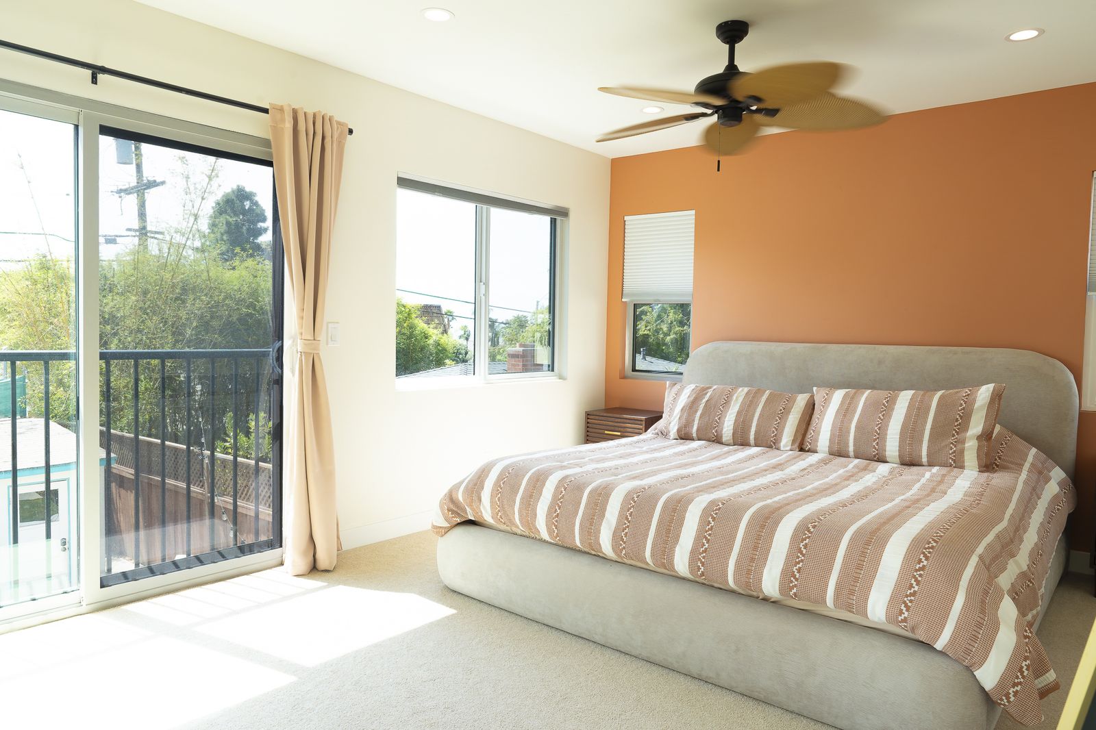 Pacific Beach second-story addition: the new primary bedroom with a balcony slider over the one-story bungalow below