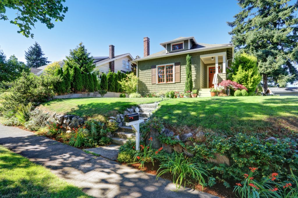 Small green American craftsman house exterior with entrance column porch